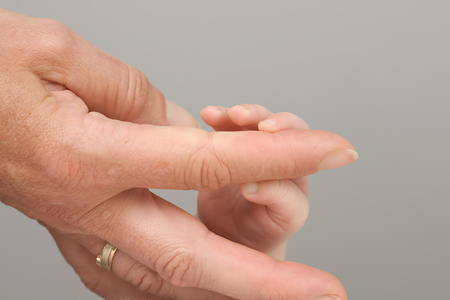 Frauenhand und Baybfinger [ (c) www.BilderBox.com, Erwin Wodicka, Siedlerzeile 3, A-4062 Thening, Tel. + 43 676 5103678.Verwendung nur gegen HONORAR, BELEG, URHEBERVERMERK nach AGBs auf bilderbox.com; und photo photos foto fotos mit in im eines einer